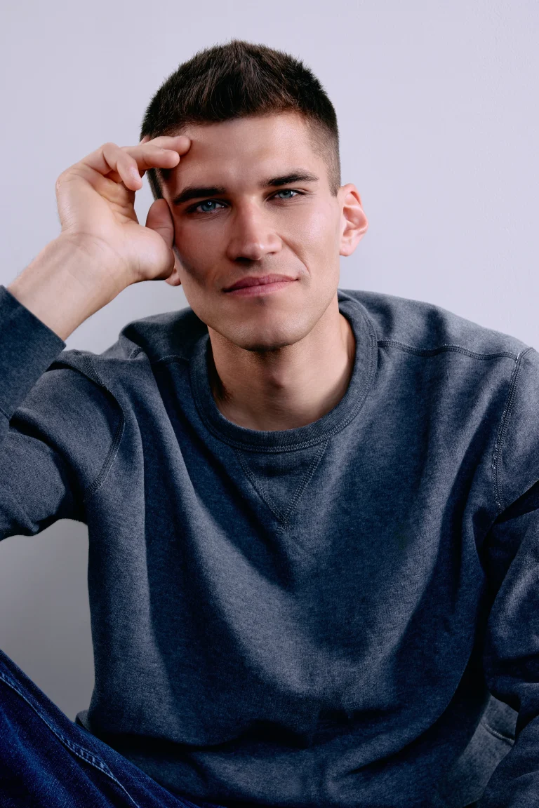 Junger Mann mit grauem Sweatshirt, Porträt