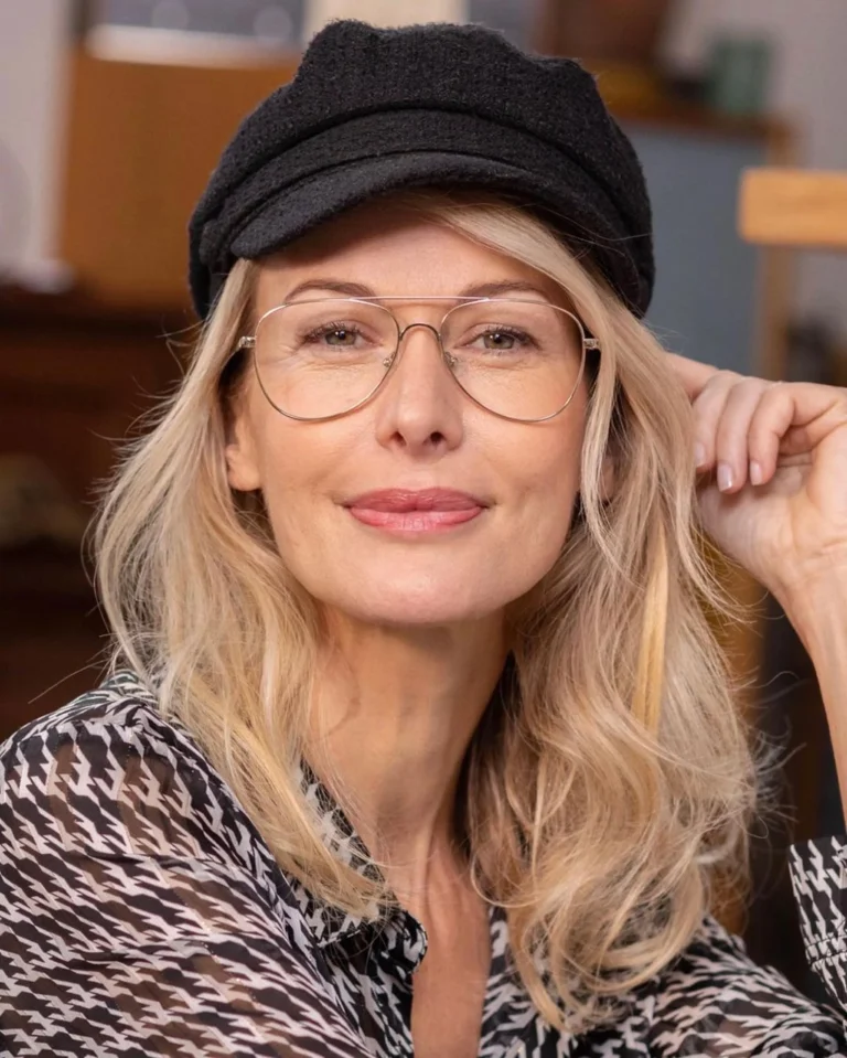 Blonde Frau mit Brille und schwarzer Mütze