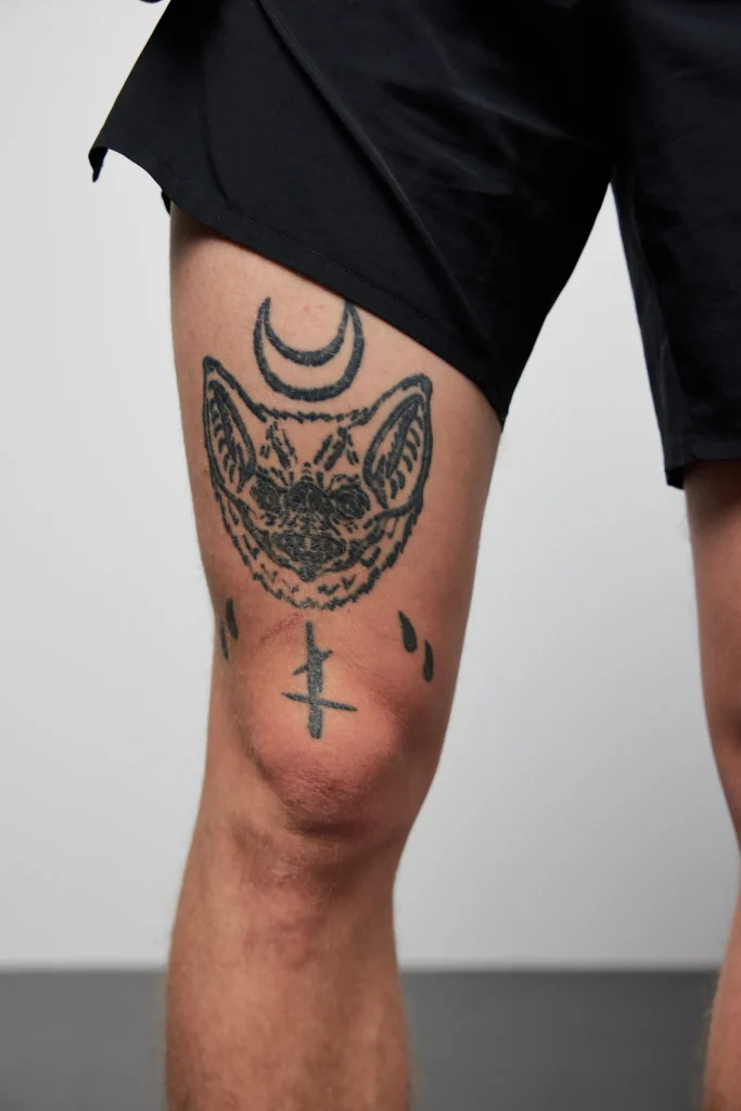 Fledermaus-Tattoo mit Halbmond am Oberschenkel