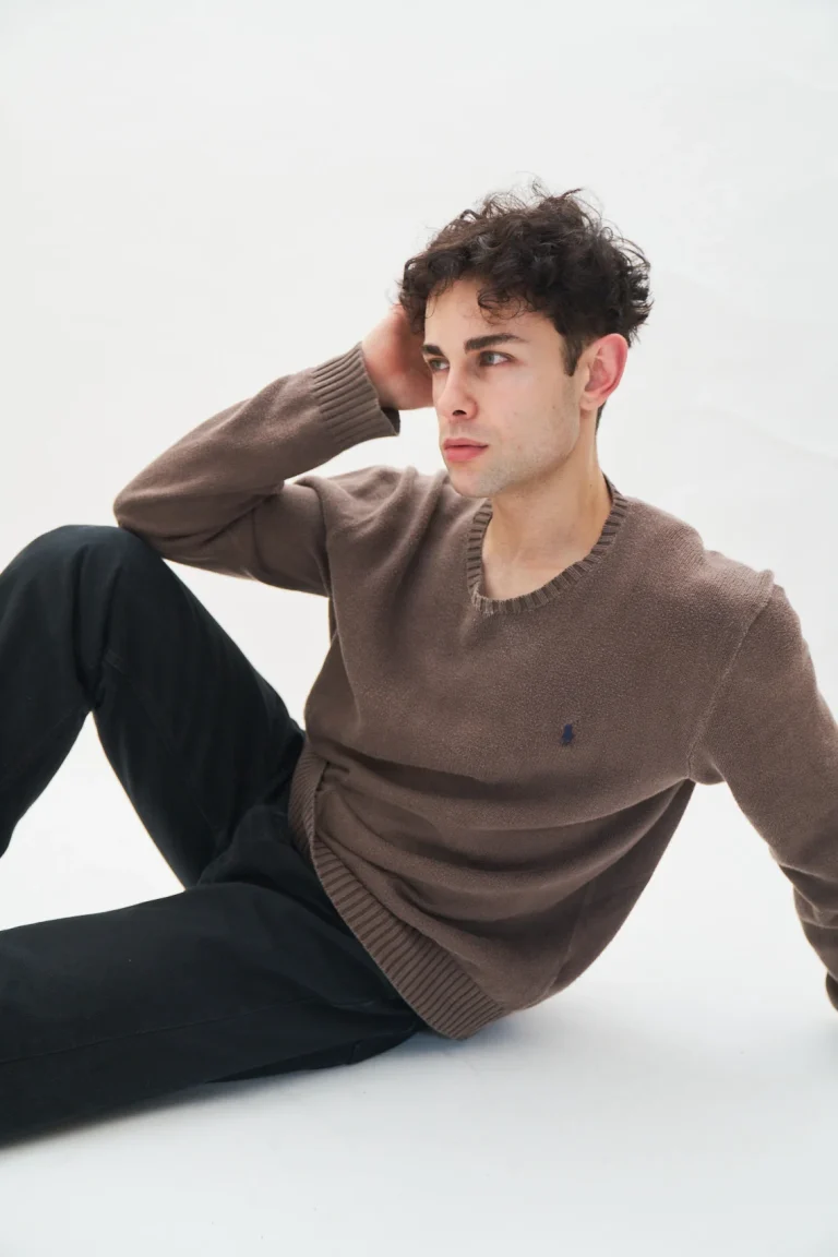 Junger Mann im braunen Pullover im Studio