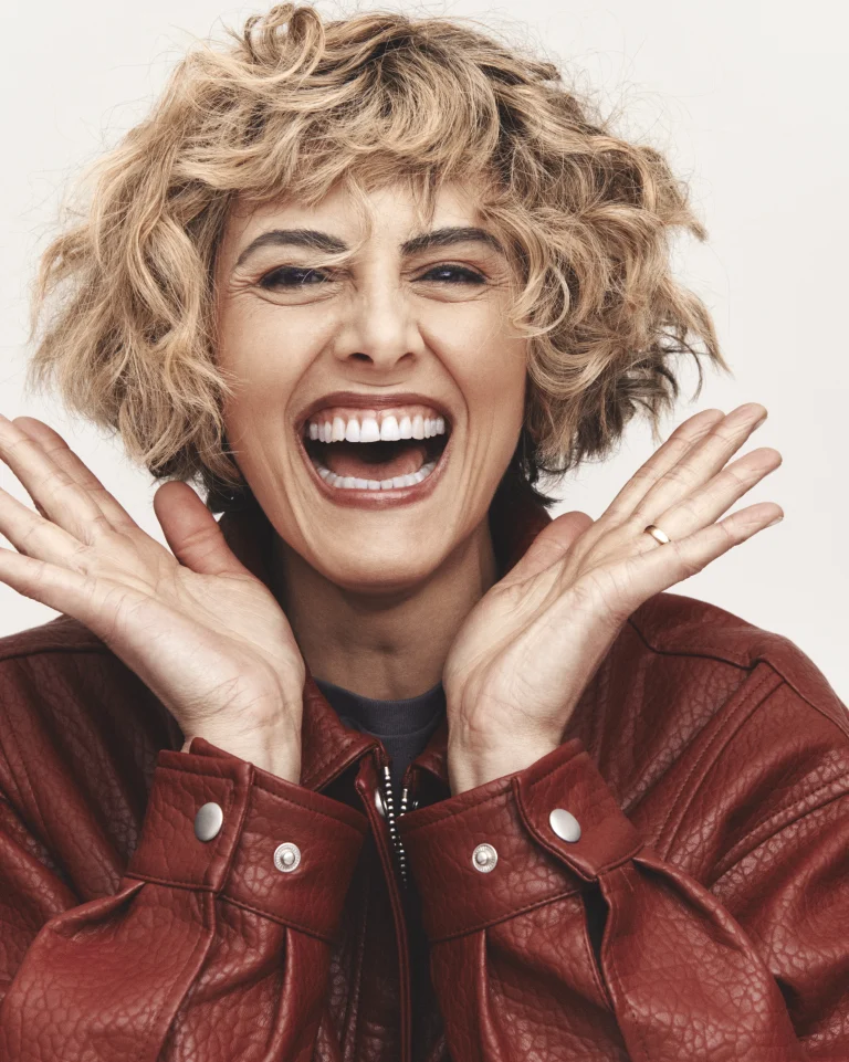 Lachende Frau mit kurzen Locken und Lederjacke