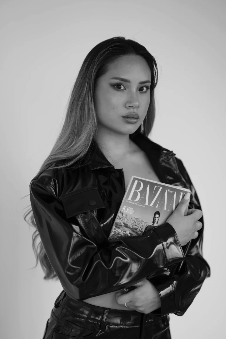 Frau mit Lederjacke hält Modemagazin in Schwarzweiß