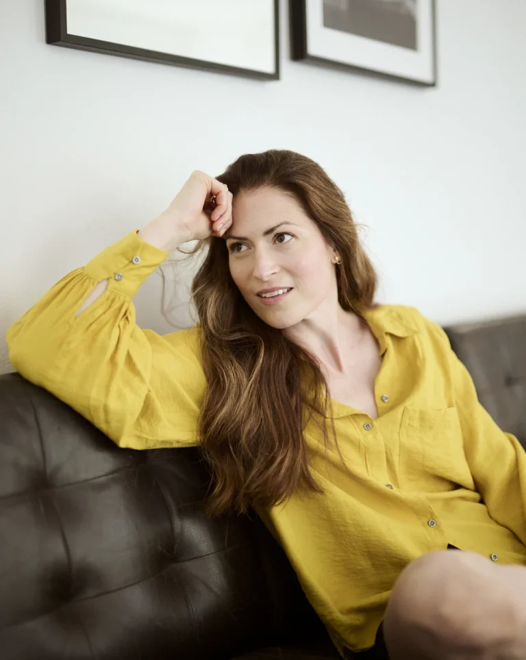 Frau in gelber Bluse entspannt auf Sofa
