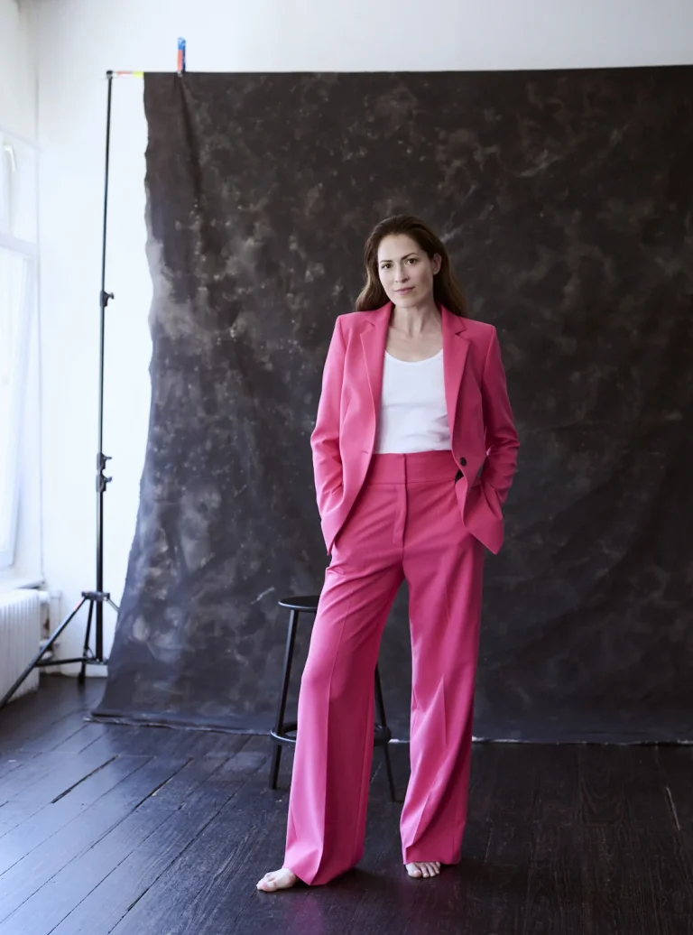 Frau im pinken Hosenanzug im Fotostudio
