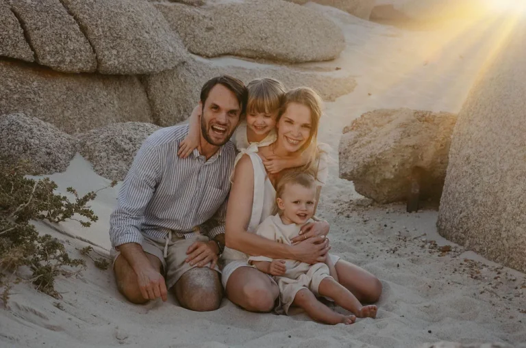 Familie mit zwei Kindern am Strand bei Sonnenuntergang