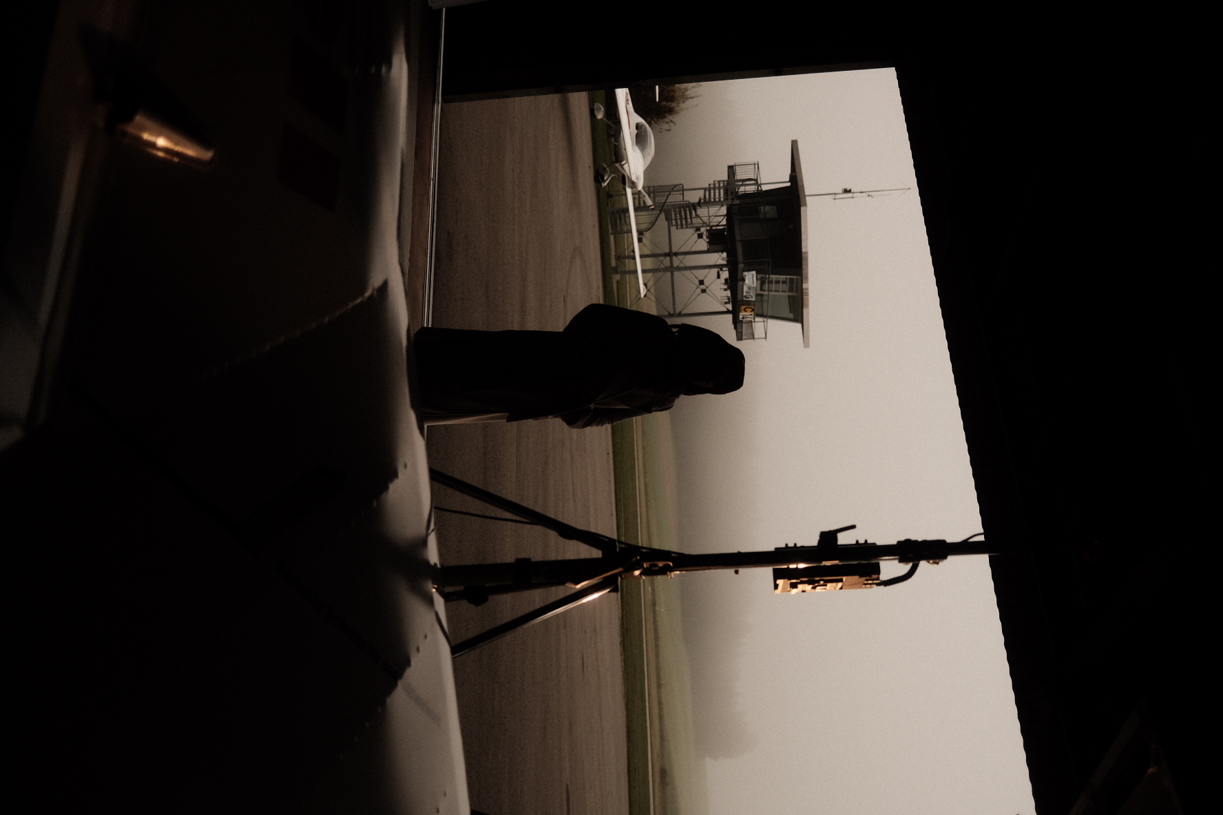 Silhouette einer Person im Hangar am Flugfeld