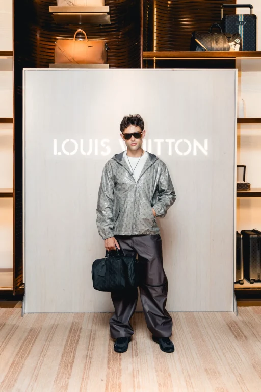 Mann mit Louis-Vuitton-Tasche vor Boutique-Theke