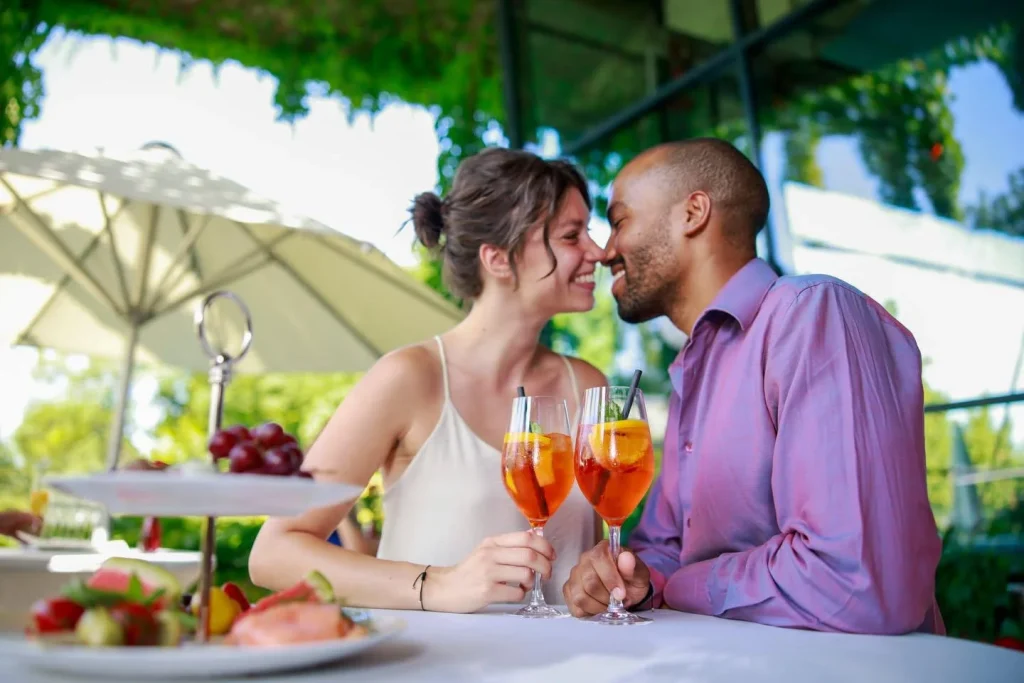 Paar stößt mit Aperol im Straßencafé an