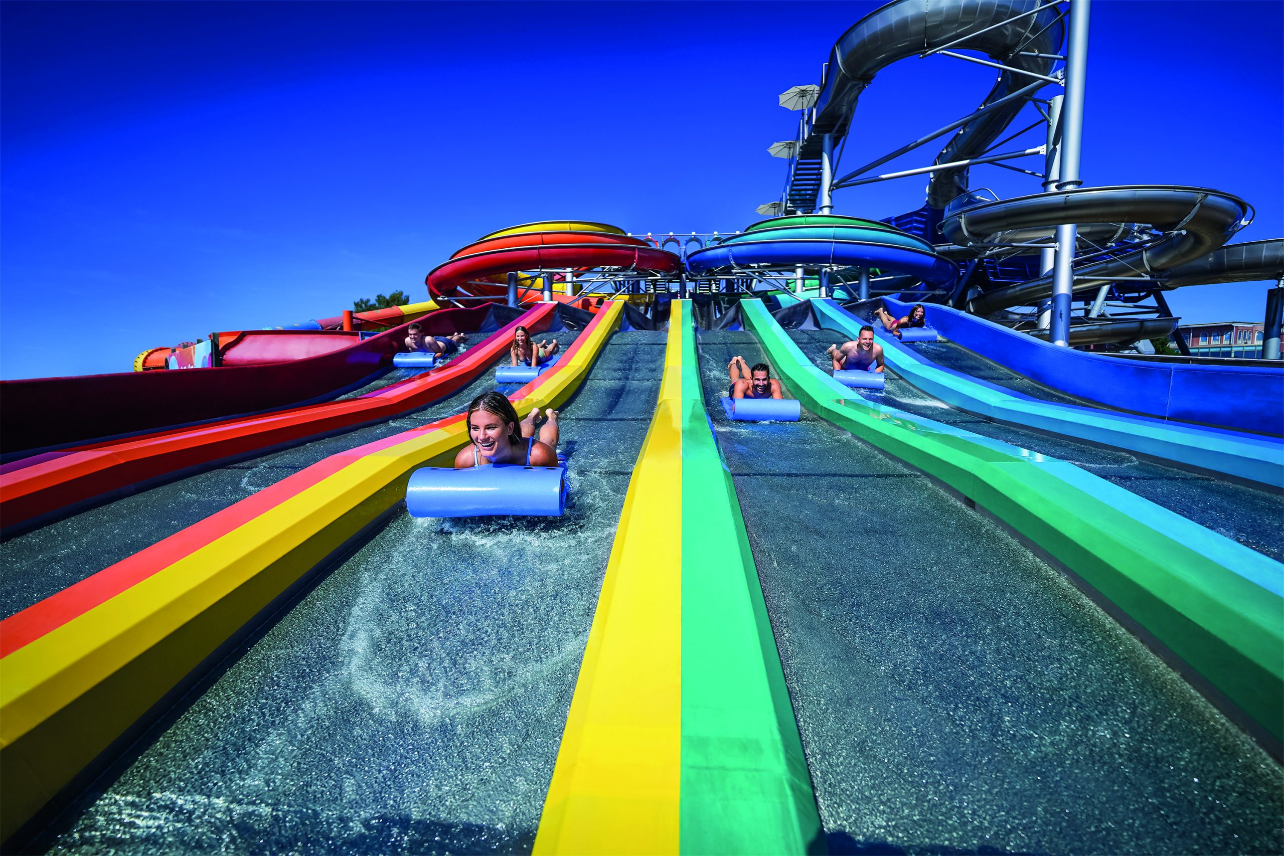 Menschen auf bunten Wasserrutschen im Freizeitpark