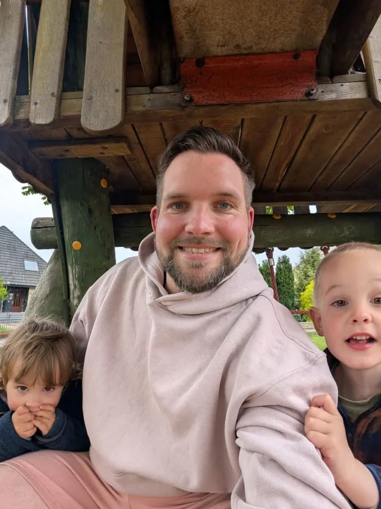 Vater mit zwei Kindern auf Spielplatz
