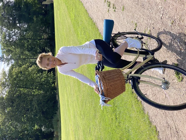 Frau mit Fahrrad im sonnigen Park