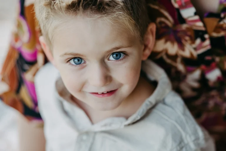 Nahaufnahme eines lächelnden Kindes mit blauen Augen
