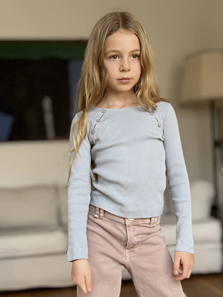 Mädchen mit langen blonden Haaren im Wohnzimmer