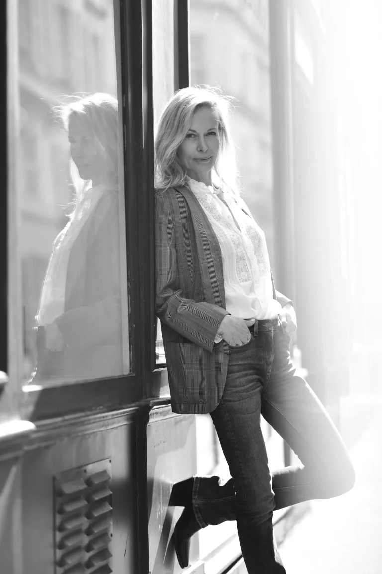 Frau lehnt an Fenster mit Spiegelung