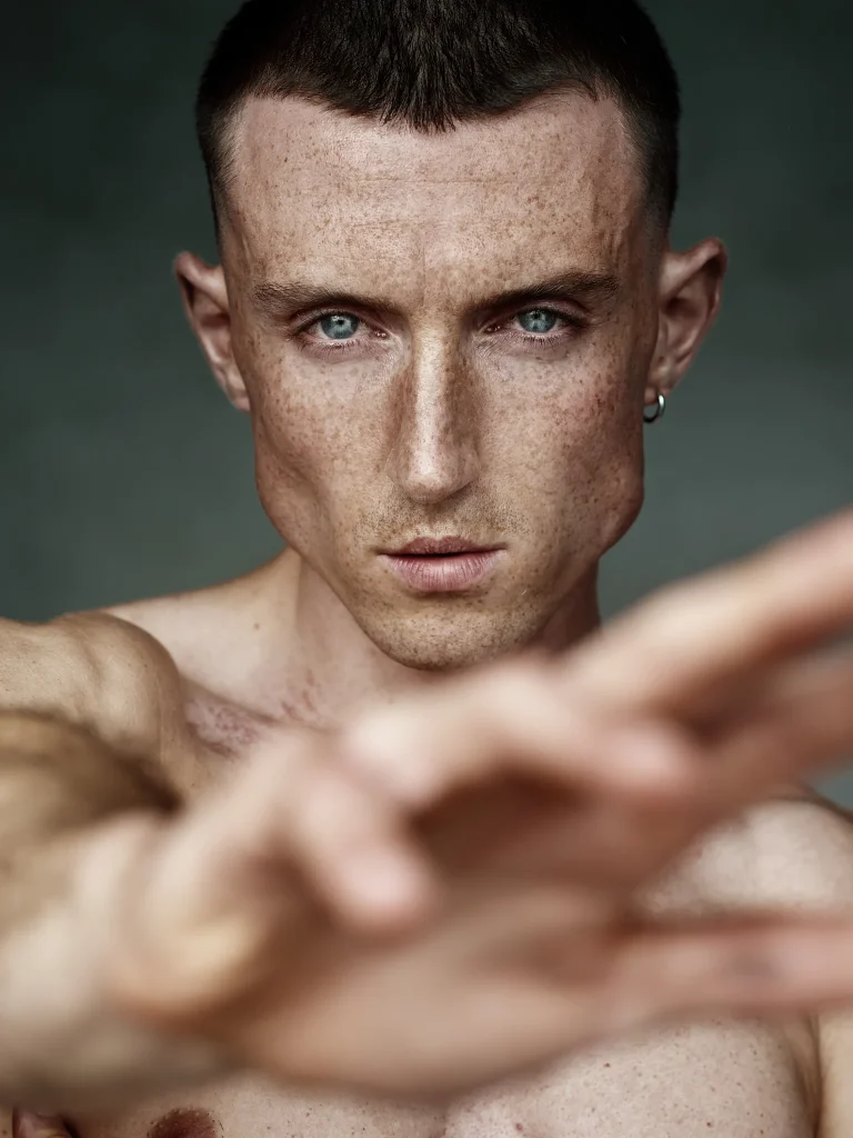 Nahaufnahme einer Person mit Sommersprossen und blauem Blick