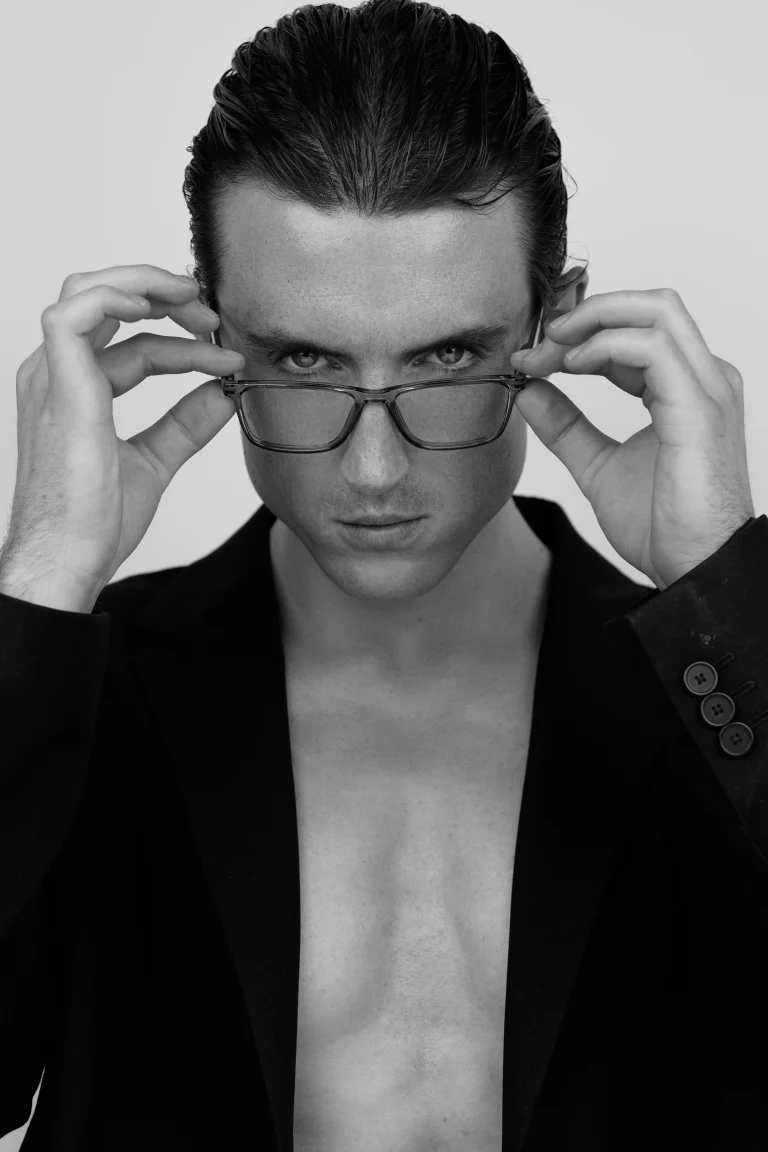 Schwarzweißporträt einer Person mit Brille, intensiver Blick