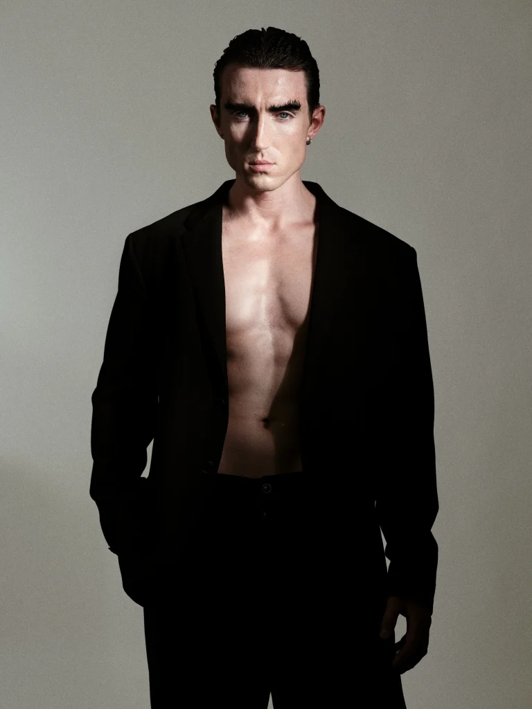 Mann mit offenem schwarzen Blazer im Studio