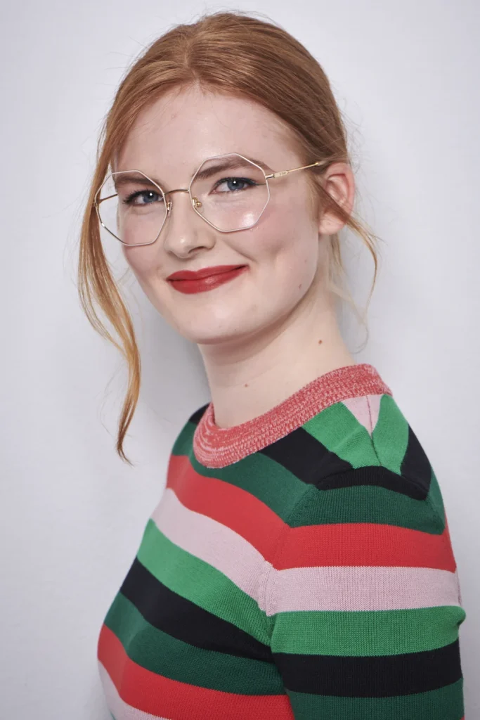 Lächelnde Frau mit Brille und gestreiftem Pullover