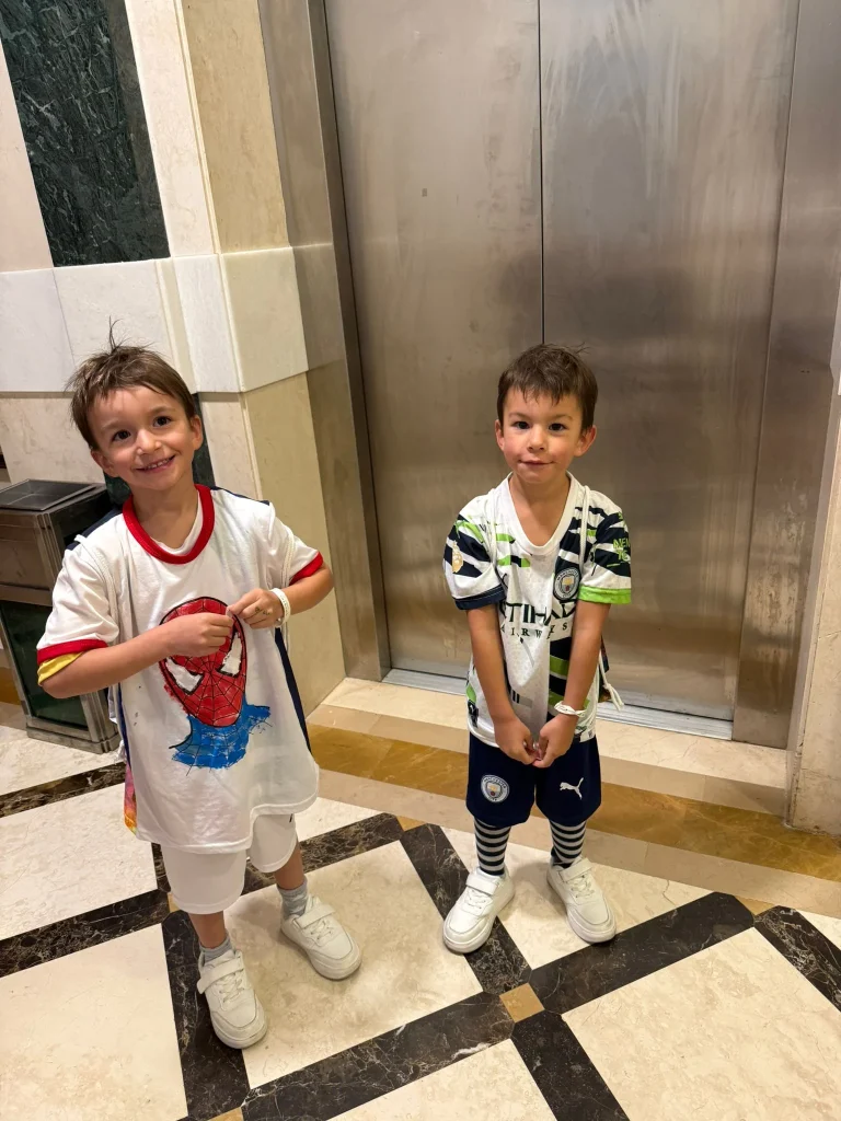 Zwei Jungen vor einem Aufzug im Gebäude
