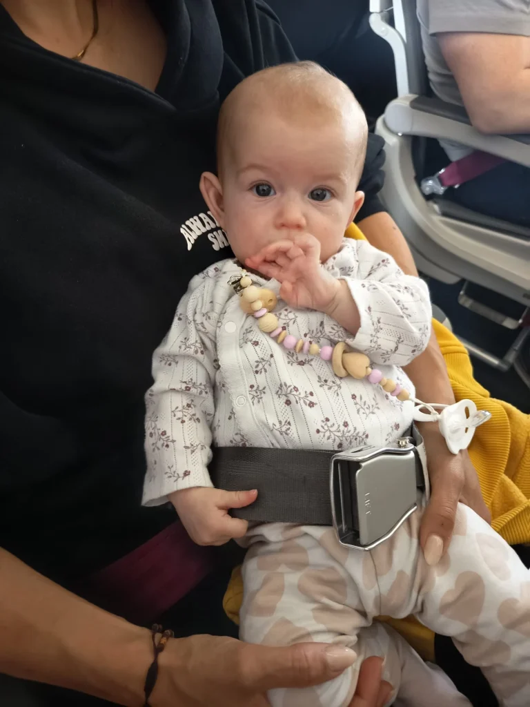 Baby mit Sicherheitsgurt im Flugzeugsitz