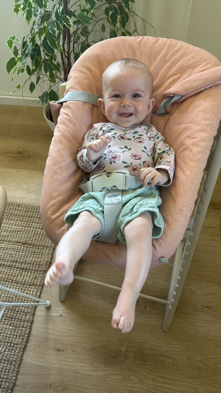 Lächelndes Baby im gepolsterten Babysitz