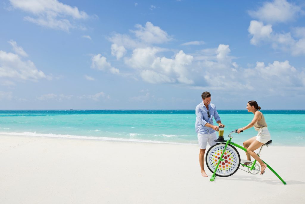 Paar mit Smoothie-Fahrrad am Strand
