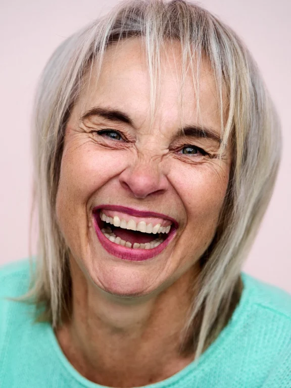 Nahaufnahme einer lächelnden älteren Frau mit blondem Haar