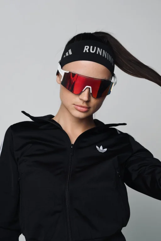Sportlerin mit roter Laufbrille und schwarzem Trainingsanzug