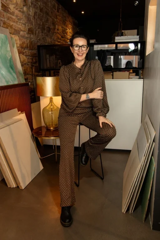 Lächelnde Frau im Atelier zwischen Leinwänden und Lampe