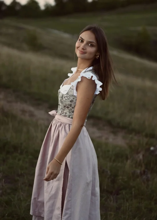 Lächelnde Frau im Dirndl auf einer Wiese