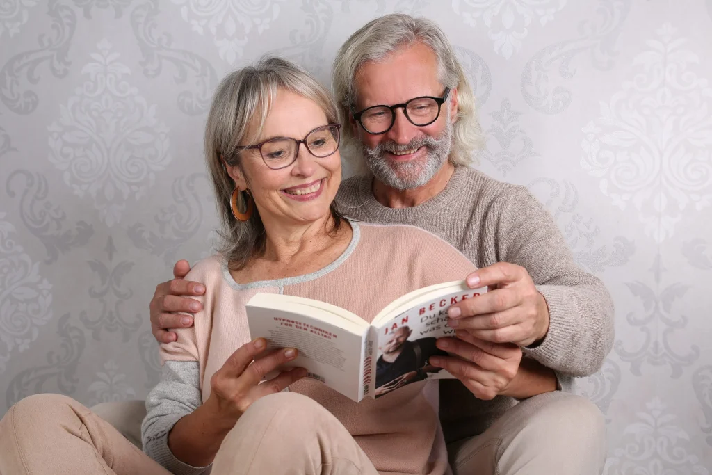 Lächelndes älteres Paar liest gemeinsam ein Buch
