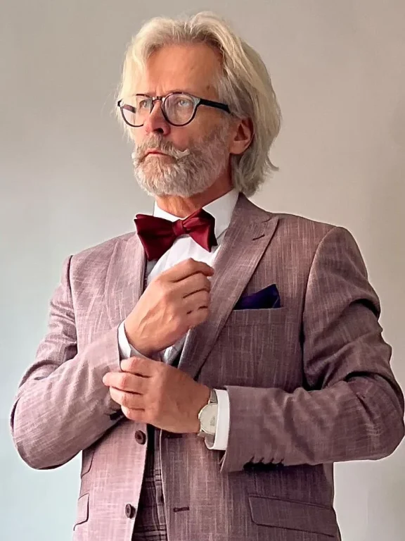 Eleganter grauhaariger Mann im Anzug mit roter Fliege