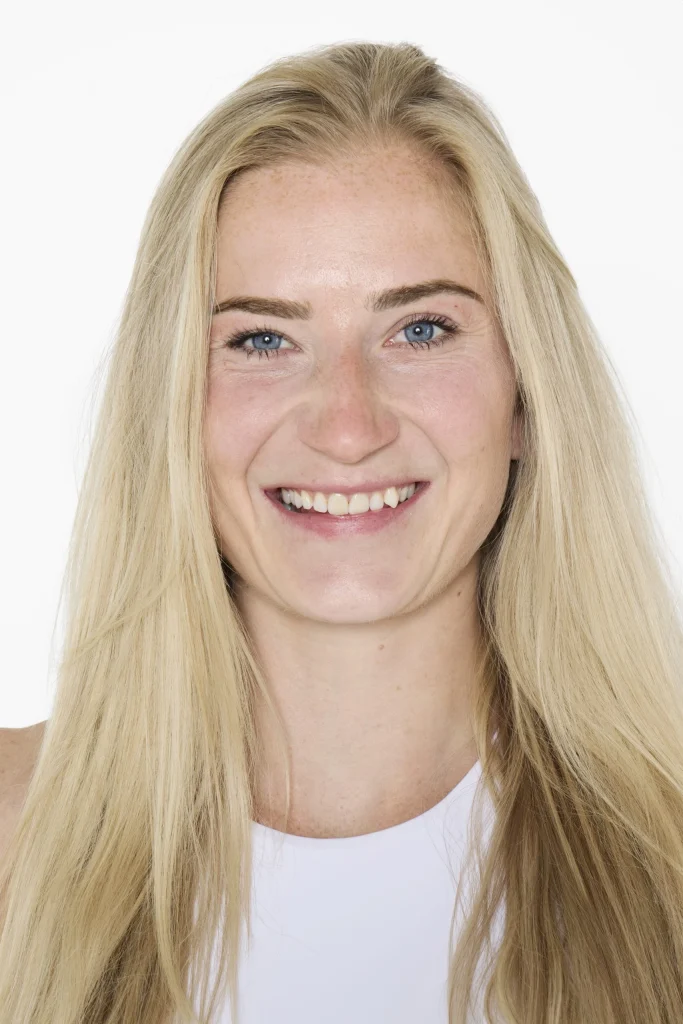 Lächelnde blonde Frau vor weißem Hintergrund