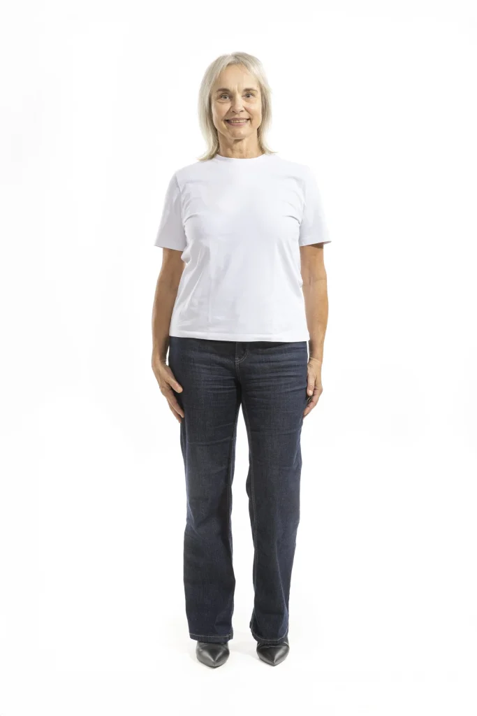 Lächelnde ältere Frau in weißem T-Shirt und Jeans