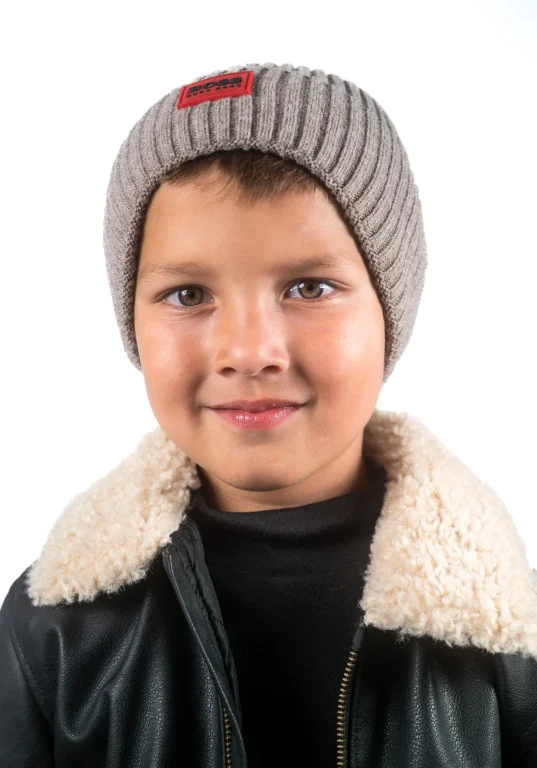 Kind mit grauer Strickmütze und Lederjacke