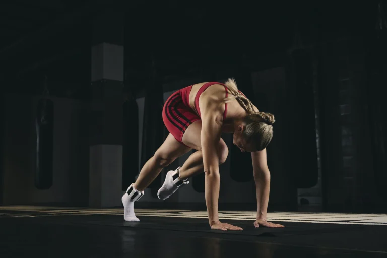 Athletin trainiert im Fitnessstudio im Vierfüßlerstand