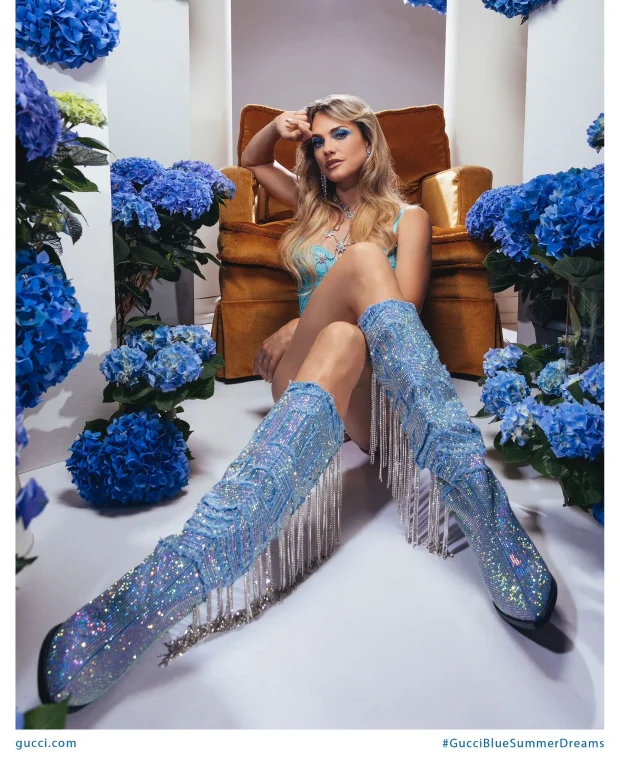 Frau in glitzernden Stiefeln zwischen blauen Hortensien